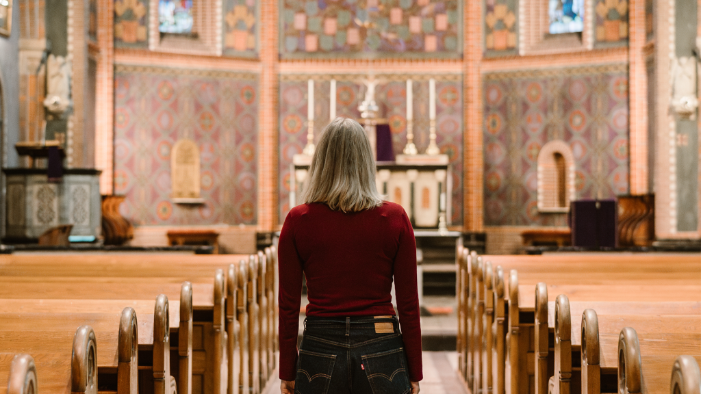 Thelma Schoon die in een kerk staat en naar het altaar en de preekstoel kijkt. 